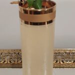 Mojito in a tall vintage glass with wide gold bands around the rim, set on a Hollywood-style vintage tray and garnished with lime and mint held by a vintage Toledo sword cocktail pick.